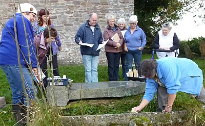 Eirwen Jones (far left) and Alison Noble (far right) advise the Llanddew group on how to identify gravestones prior to recording the inscriptions.